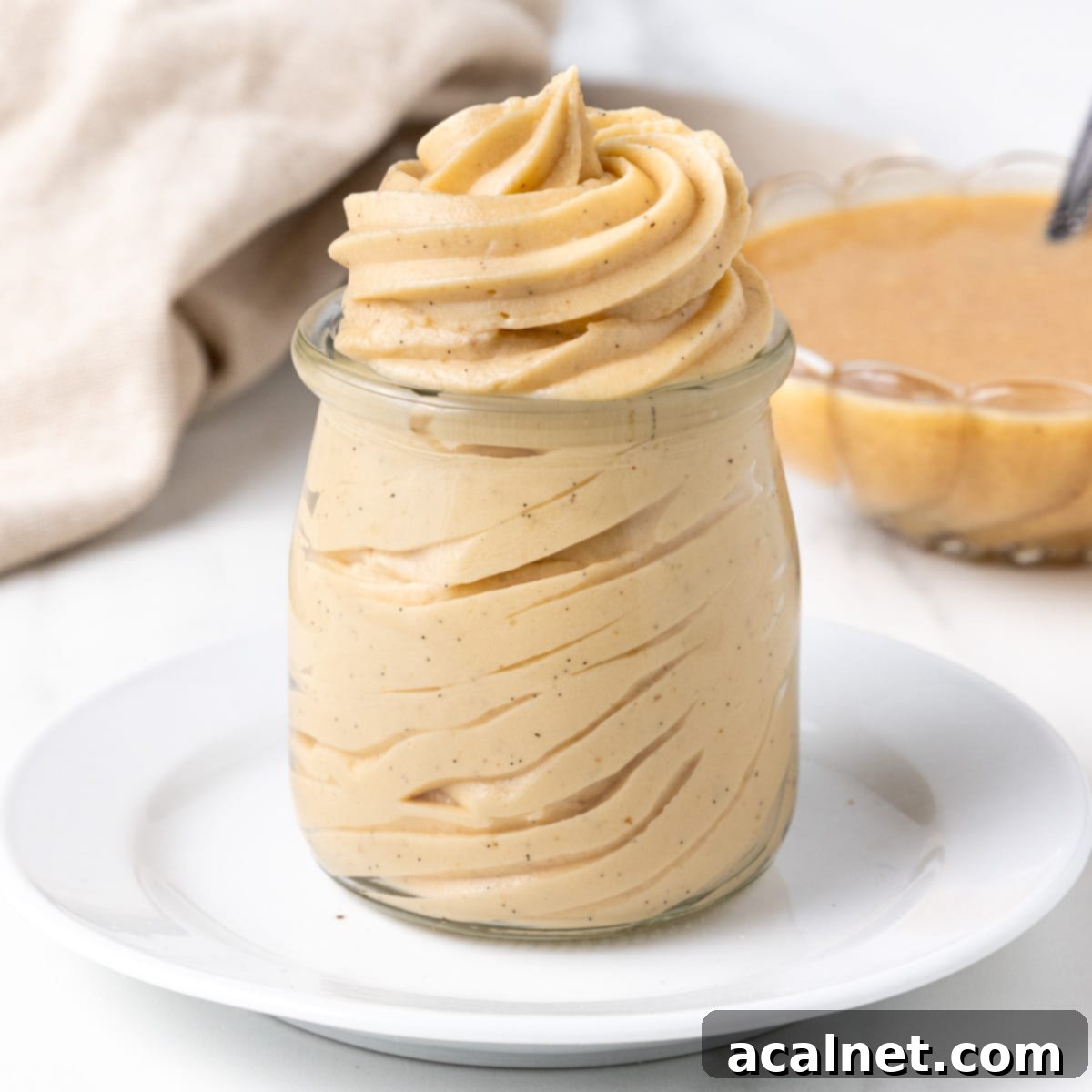 Velvety Praline Mousseline 2 Swirls of praline mousseline cream piped inside a yogurt glass jar, showcasing its smooth and fluffy texture.
