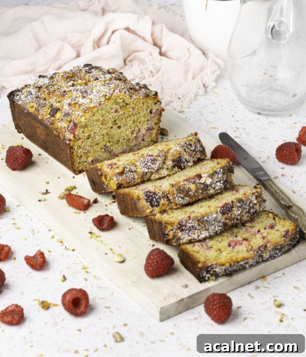 Loaf Cake on a wooden cutting board, half sliced.
