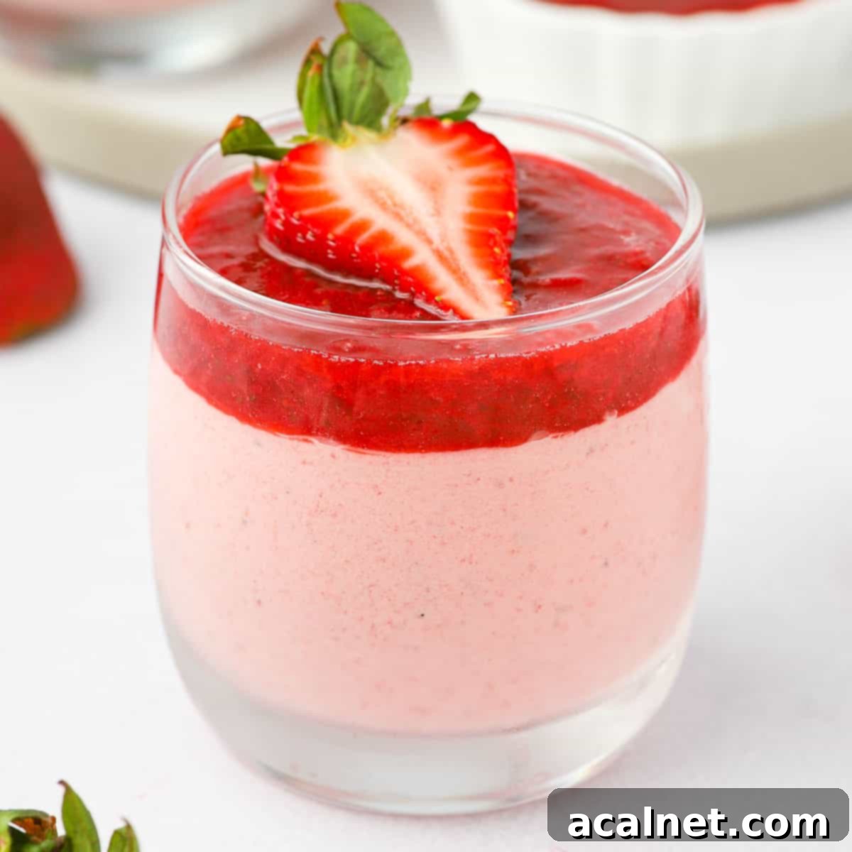 15+ Decadent Mousse Delights 11 Close up on the beautiful pink strawberry mousse in a glass, garnished with fresh mint.