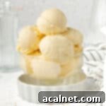 Ice Cream in a dessert cup inside a small white dish with striped napkin in the background.