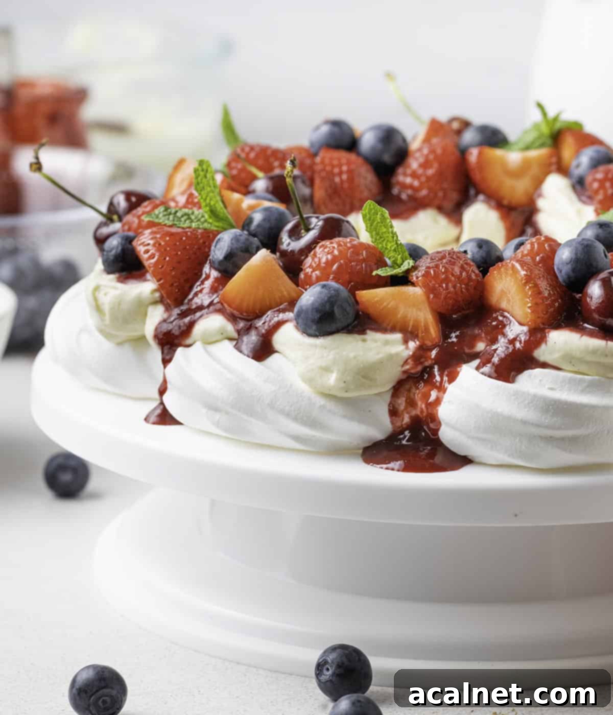 Close up on coulis dripping from the side of the pavlova.