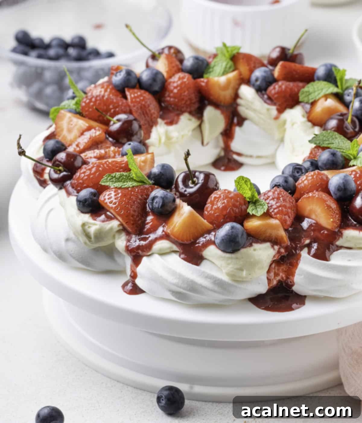 Side view of the wreath over a white cake stand with blueberries in the background.