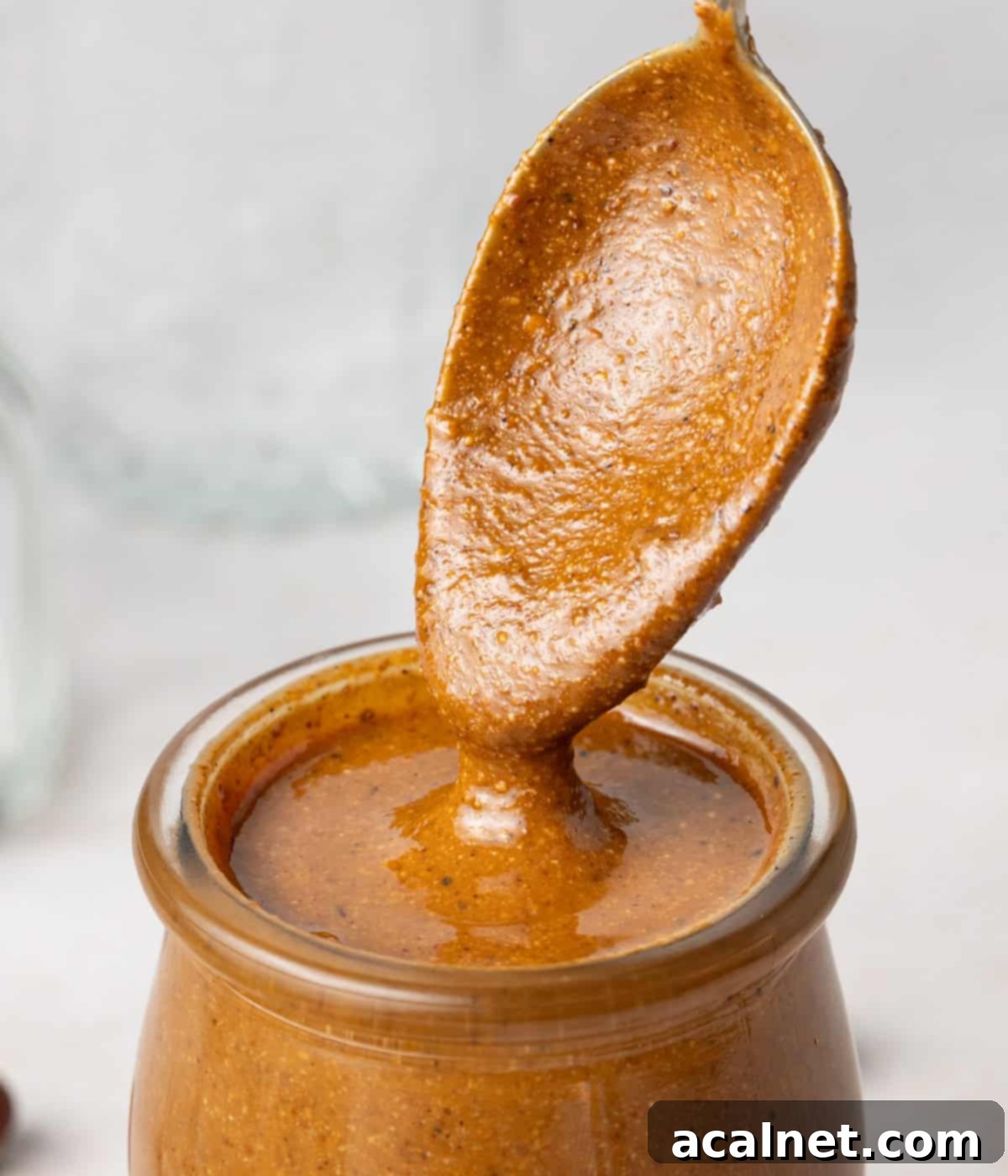 Crafting Homemade Hazelnut Butter 5 Close up on the spread dripping from a spoon to a jar.