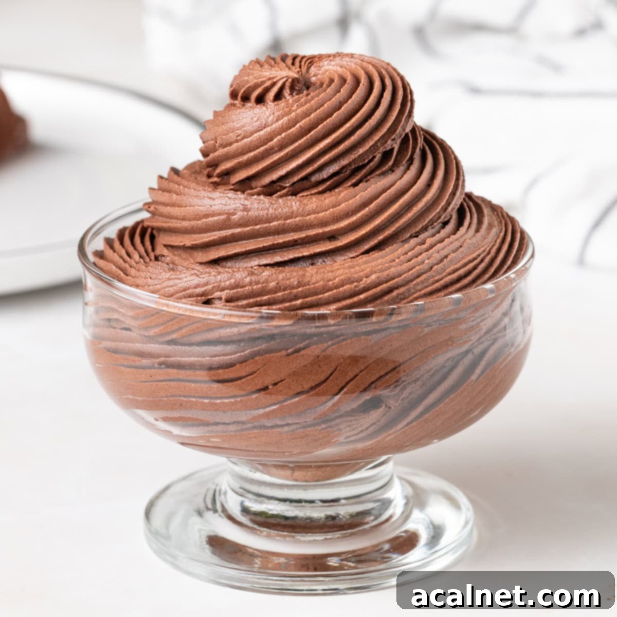 Chocolate Cloud Frosting 2 Chocolate whipped cream piped into a high swirl inside a glass dessert cup.