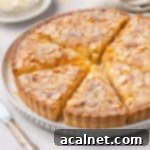 Sliced almond tart on a white plate.