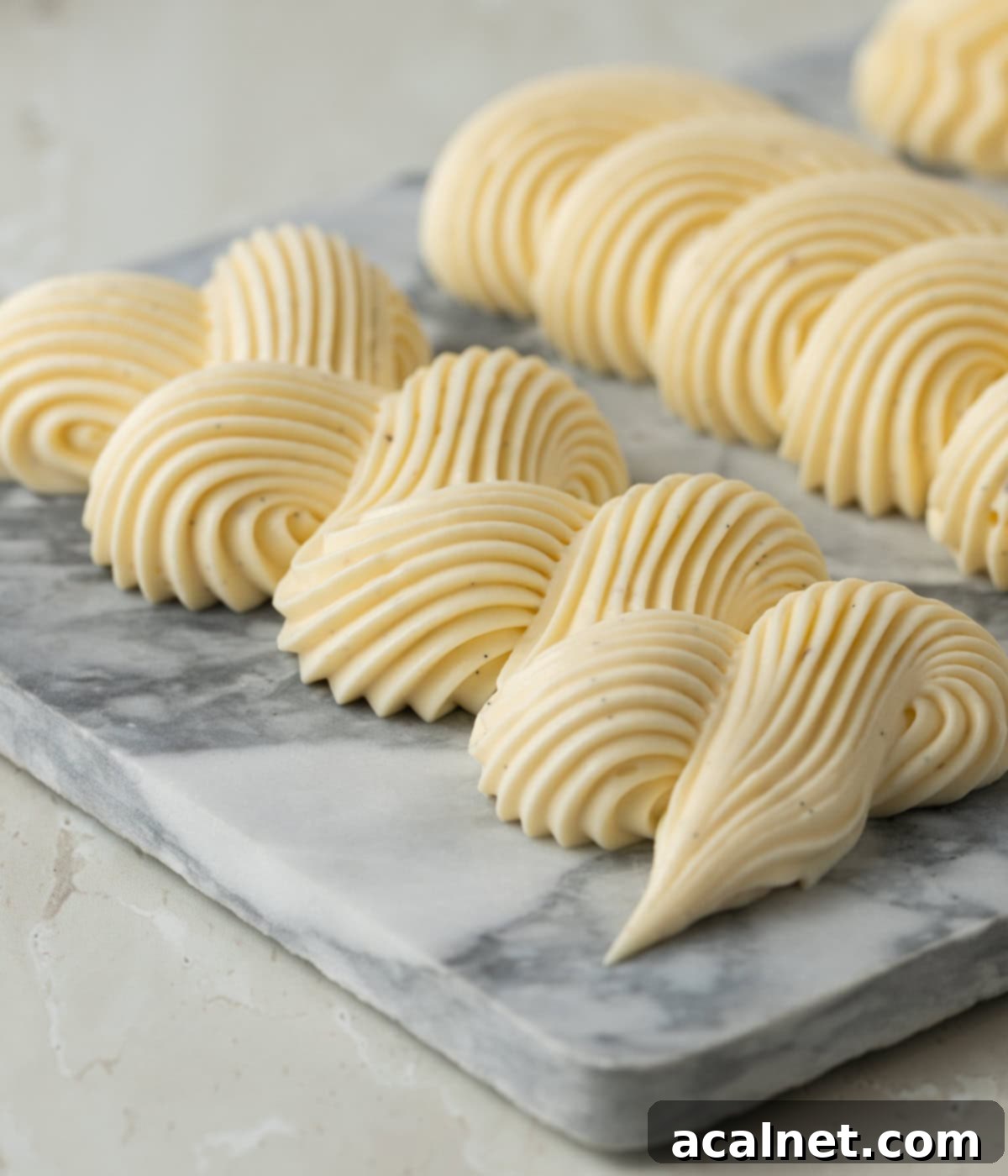 Light Pastry Cream 7 A delicate swirl line of Crème Légère piped onto a marble plate, showcasing its smooth and soft texture, ready for garnishing or serving.