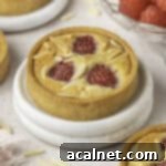 Ruby Raspberry Almond Tarts 12 Close up on a small tart placed over two white coaster.