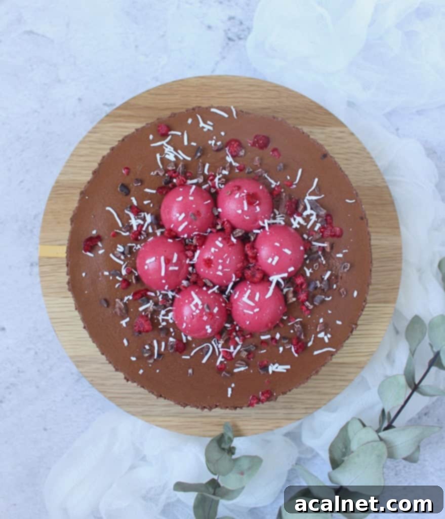Flatlay photo of the cake on a round wooden board with green leaves