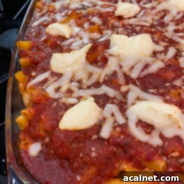 Ultimate Cheesy Ziti Bake 9 A close-up shot of a large pan of Cheesy Baked Ziti Casserole, featuring the bubbling red sauce and melted, golden-brown cheese on top.