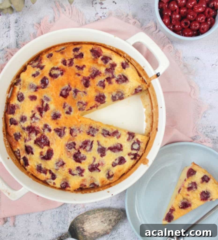 Clafoutis in a round ceramic dish with one slice placed on a blue plate