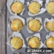 Savory Zucchini and Goat Cheese Muffins 7 Beautifully baked Zucchini Muffins with Goat Cheese, presented on a wooden surface.