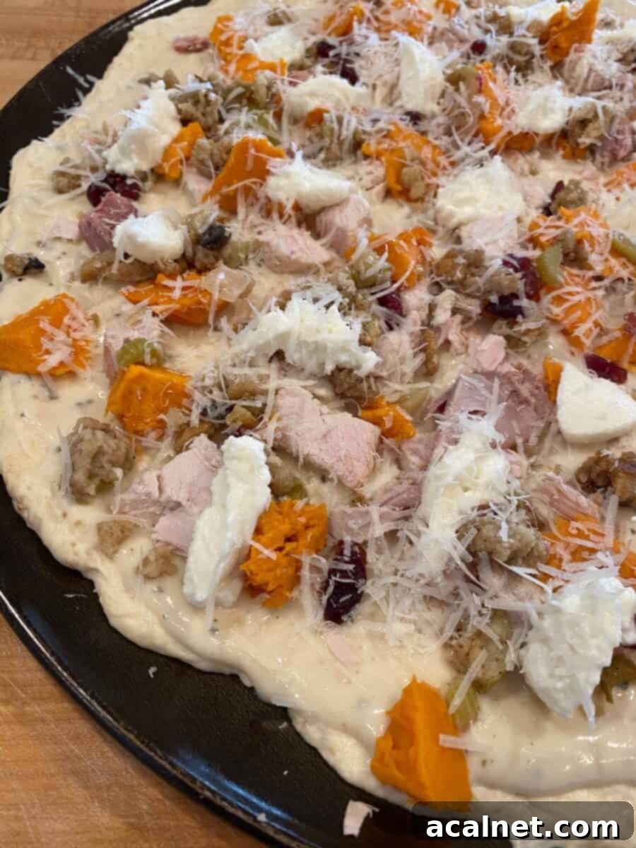 Turkey Reimagined Pizza 2 Unbaked leftover turkey pizza with turkey, stuffing, sweet potatoes, cranberries, and dollops of ricotta.
