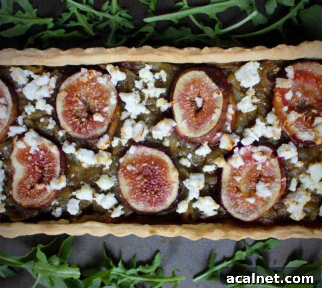 Close-up of a golden Feta Fig Onion Tart with a flaky crust and visible fillings of figs, feta, and caramelized onions.