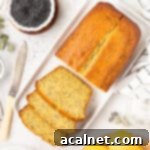 Zesty Lemon Poppy Seed Loaf 9 Loaf cake on a white rectangular plate with 3 slices cut off, showing its moist crumb.