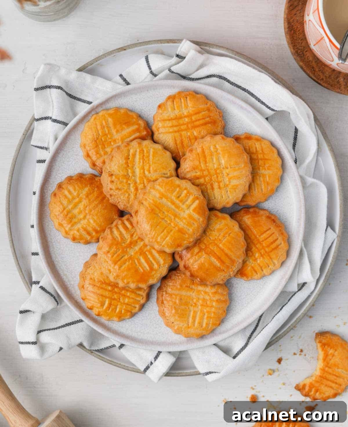 Buttery Breton Cookie Delights 3 Sablés Bretons Cookies arranged on a white plate, viewed from above, highlighting their perfect round shape and golden finish.