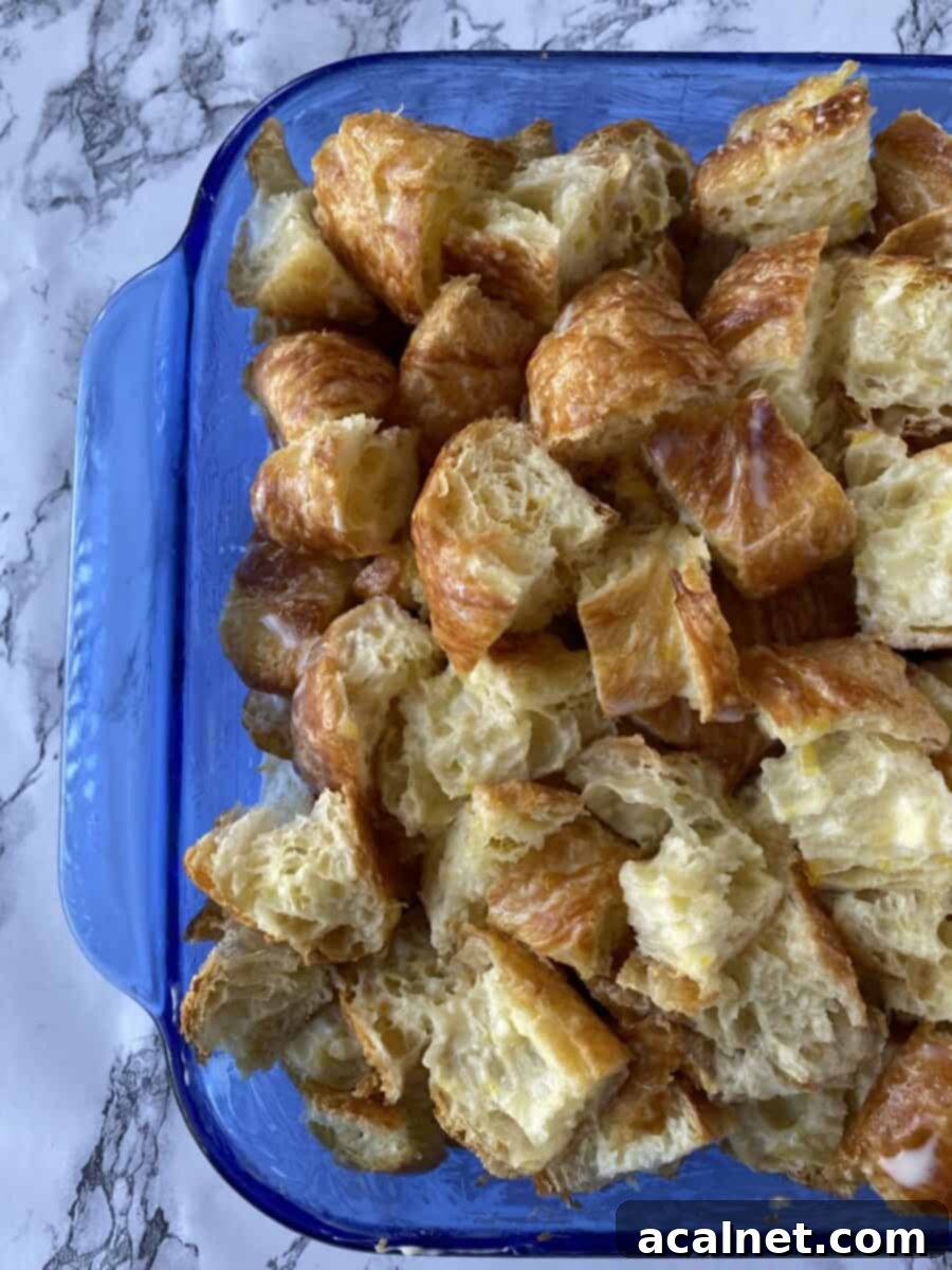 Diced croissants in a glass baking dish.
