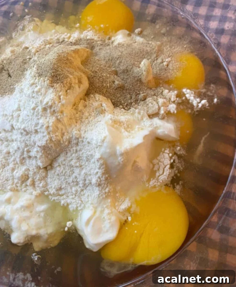 Egg bite ingredients, including eggs, cottage cheese, and Greek yogurt, in a mixing bowl.
