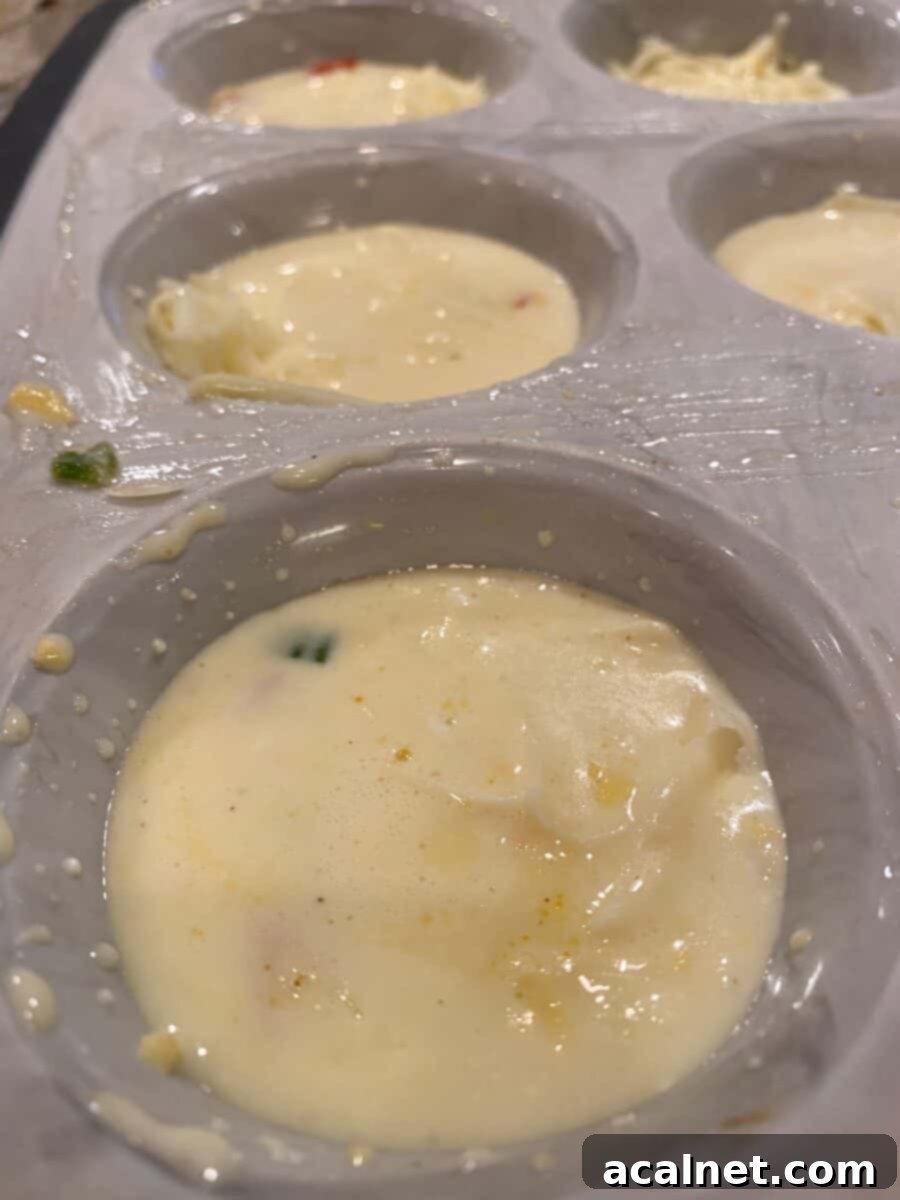 Muffin cups nearly filled with the liquid egg bite ingredients and toppings, showing adequate space at the top.