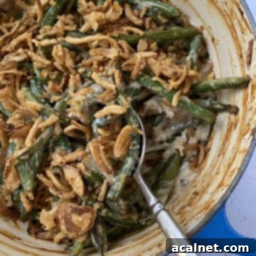 Baked green bean casserole with a serving spoon.
