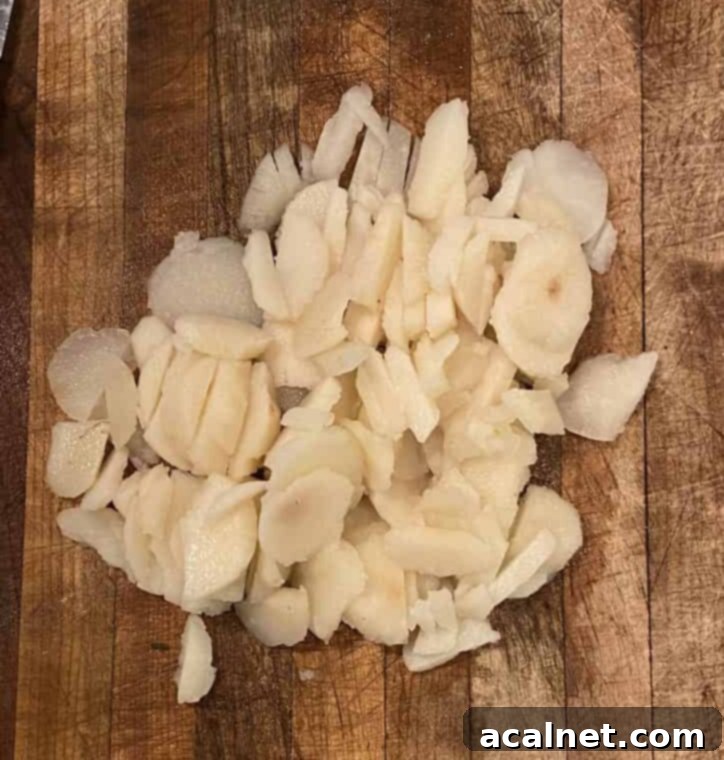 Diced water chestnuts scattered on a cutting board, prepared for inclusion in the casserole.