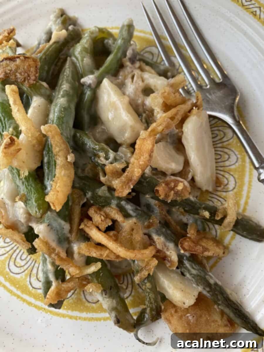 A generous serving of Elegant Green Bean Casserole on a white plate, highlighting its creamy texture and fresh green beans, ready to be enjoyed.