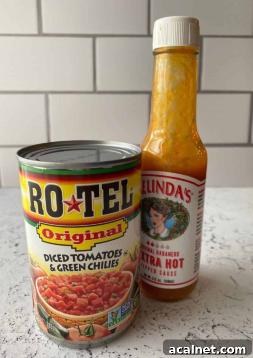 One can of Rotel tomatoes and a jar of hot sauce on a kitchen counter, highlighting the key spicy ingredients.