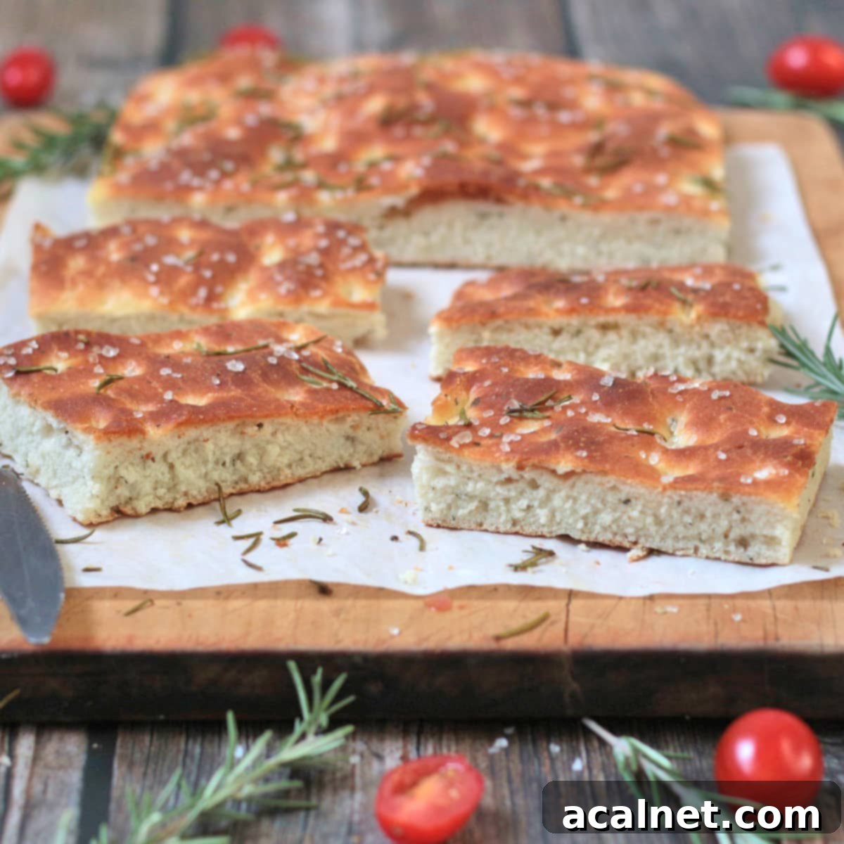 Effortless Rosemary Focaccia Perfection 2 Slices of bread on a wooden cutting board.