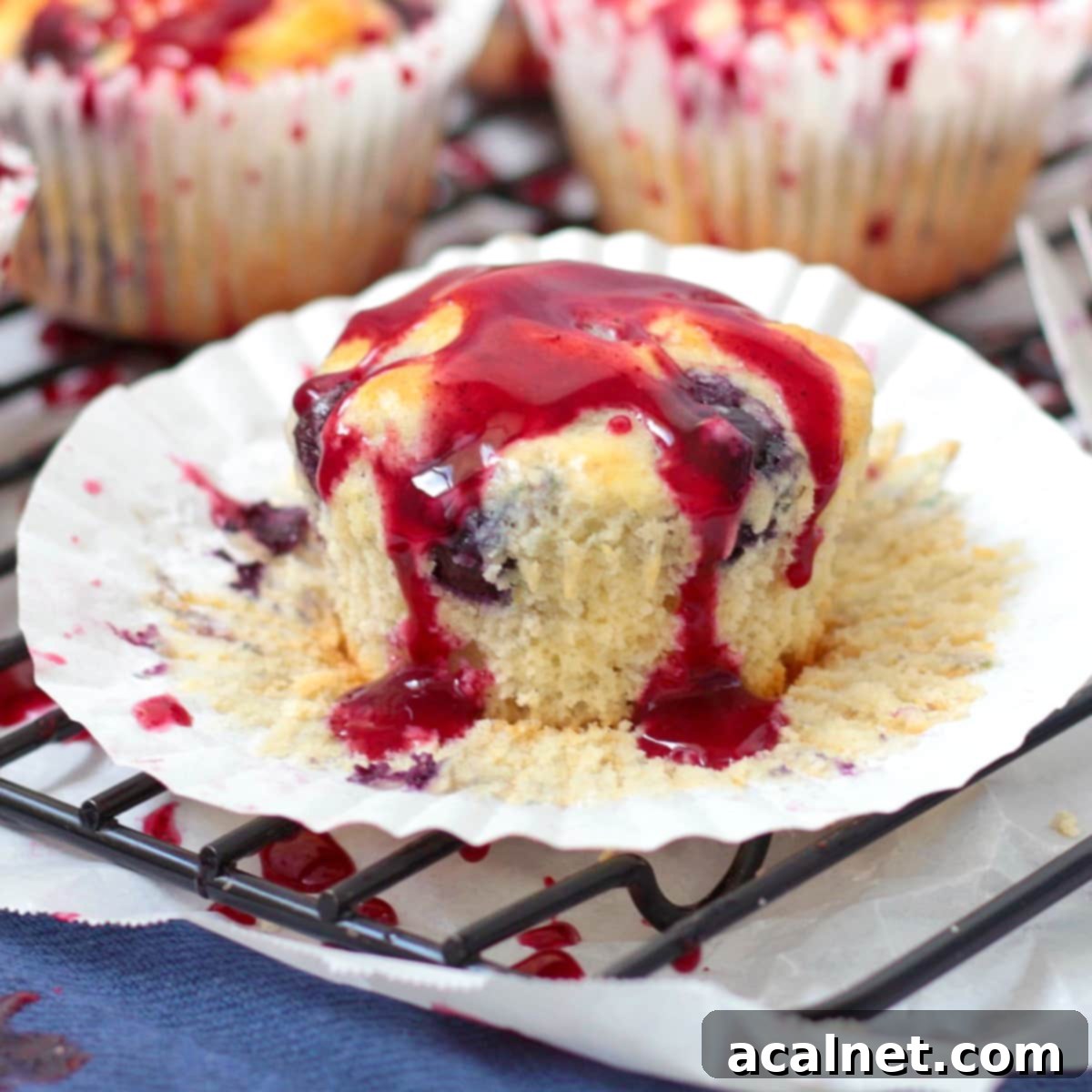 Perfectly baked Lemon Blueberry Muffin with a generous drizzle of zesty glaze, sitting on a paper case.