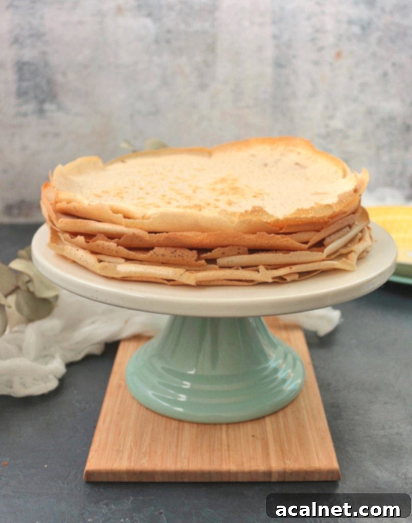 A beautifully presented stack of Buckwheat Crêpes on a beige and green cake stand, ready to be enjoyed with various fillings.
