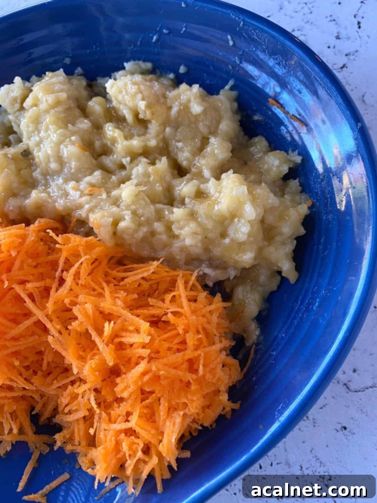 Shredded carrots and mashed bananas in a dish.