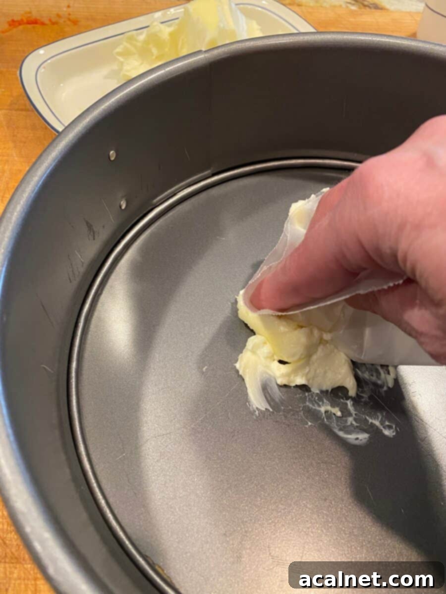 A springform pan with a dollop of butter.