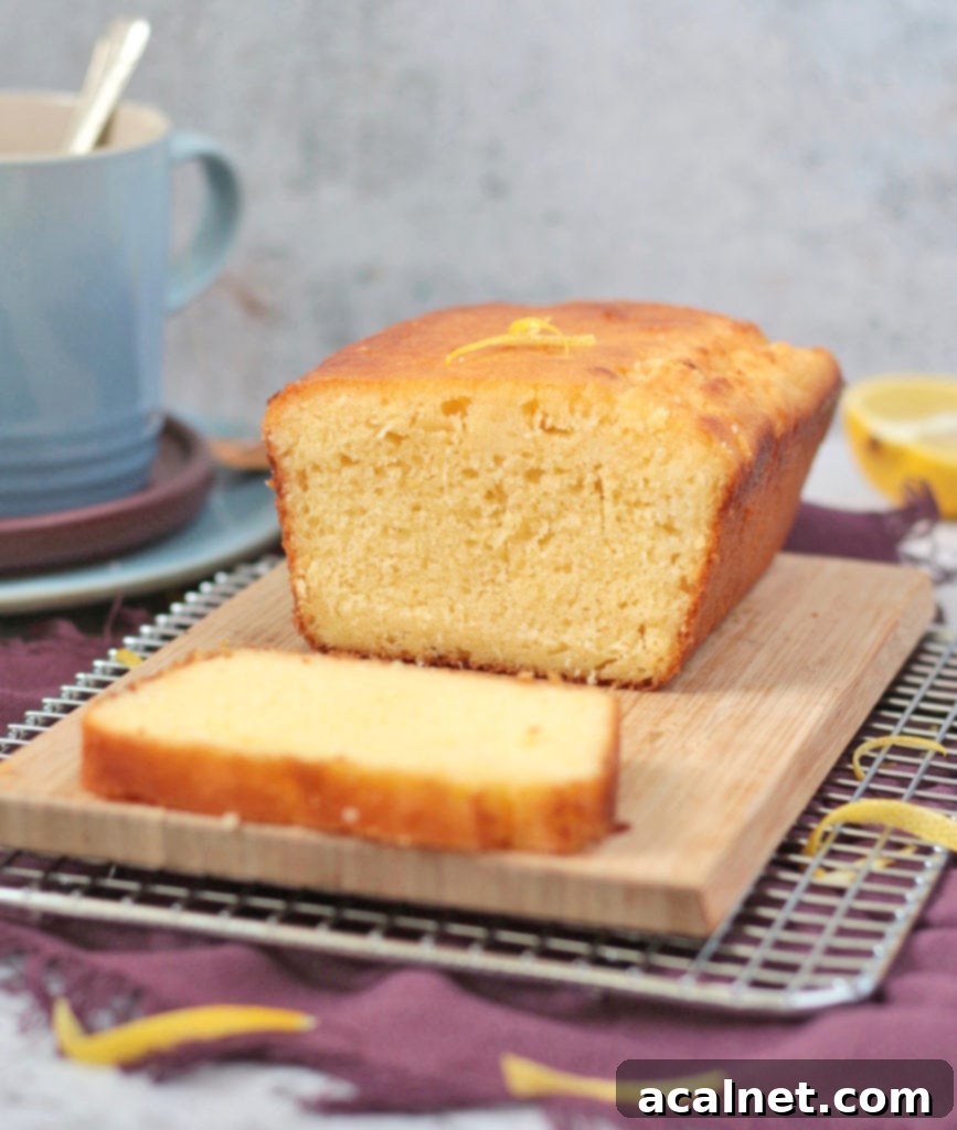 A perfectly sliced homemade Lemon Drizzle Cake with a clear, tangy glaze