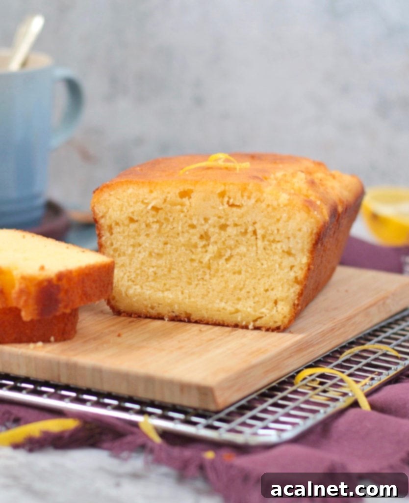 Close up on a slice of homemade Lemon Drizzle Cake, highlighting the texture and drizzle