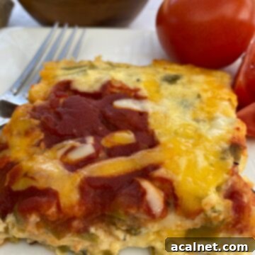 Fiesta Green Chile Egg Casserole 11 Side view of the casserole with tomatoes and a bowl of salsa in the background.
