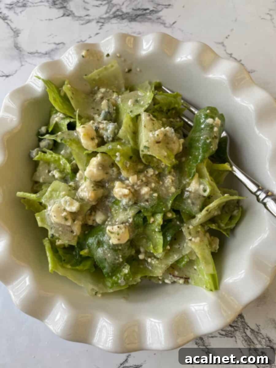 Salad greens in a small bowl covered with blue cheese vinaigrette, a copycat version of Buddy's Salad Dressing. 