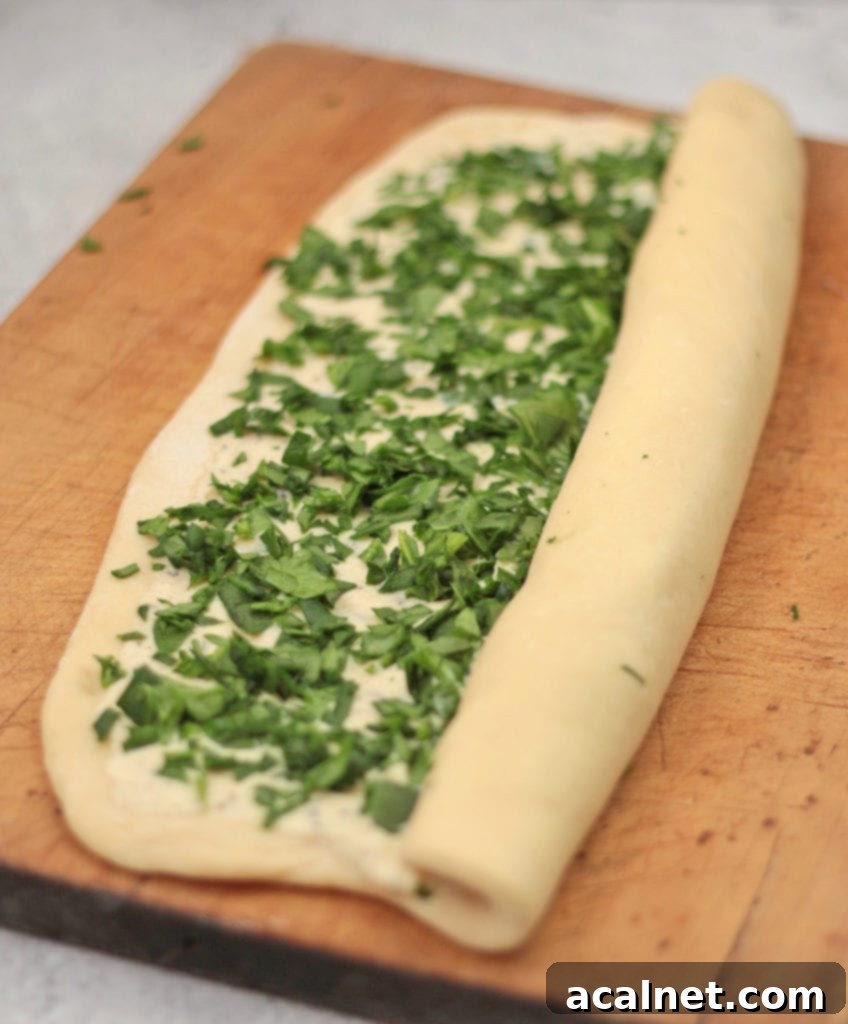 Process shot: rolling the bread dough over the spinach and ricotta filling to create the scrolls