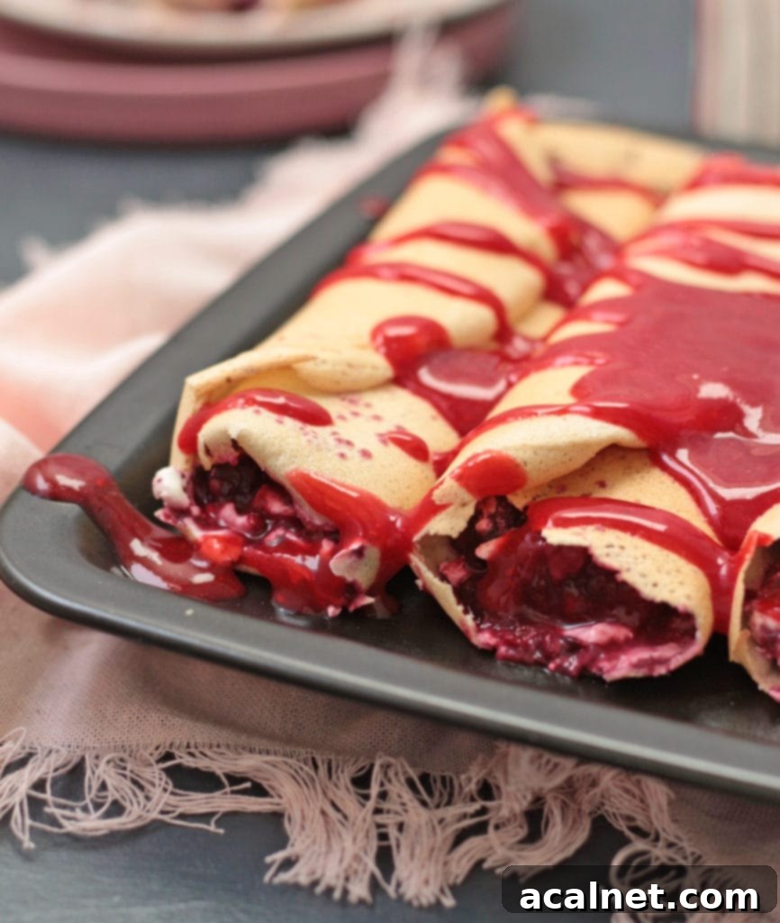 Ultimate Sweet Pancake Topping Guide 3 Raspberry Coulis drizzled over a stack of crepes, with fresh raspberries on the side.