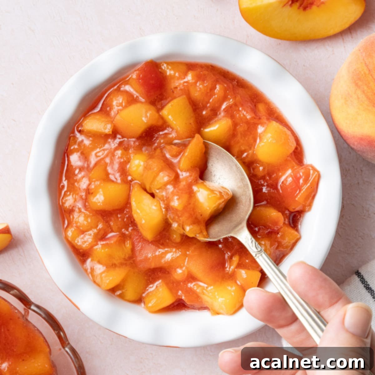 Ultimate Sweet Pancake Topping Guide 6 Small white bowl filled with peach compote, with a silver spoon, viewed from above.