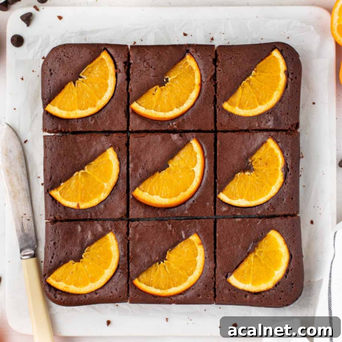 Brownies sliced in 9 on a marble cutting board seen from above.
