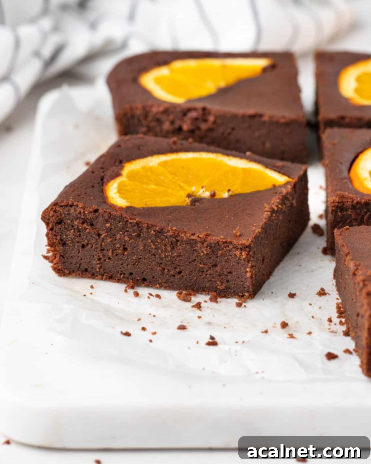 Brownies slice on baking paper over a square marble board.