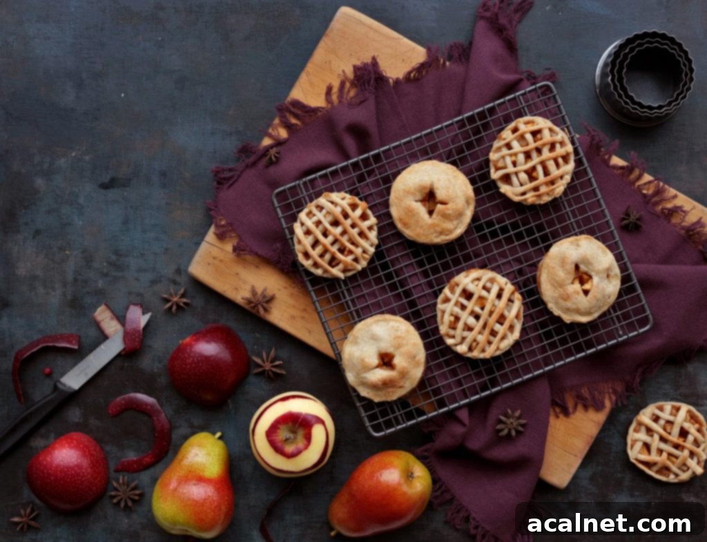 Mini Apple Pies with fresh fruits on a wooden board