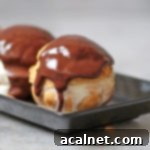 Close-up zoom on one perfect choux bun covered with rich, warm chocolate sauce