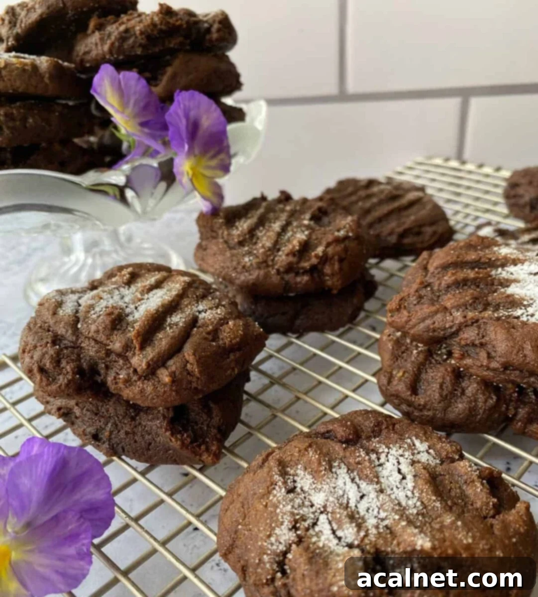 Molasses Snaps arranged on a cooling rack, accompanied by a delicate pansy flower, showcasing their fresh-baked appeal.