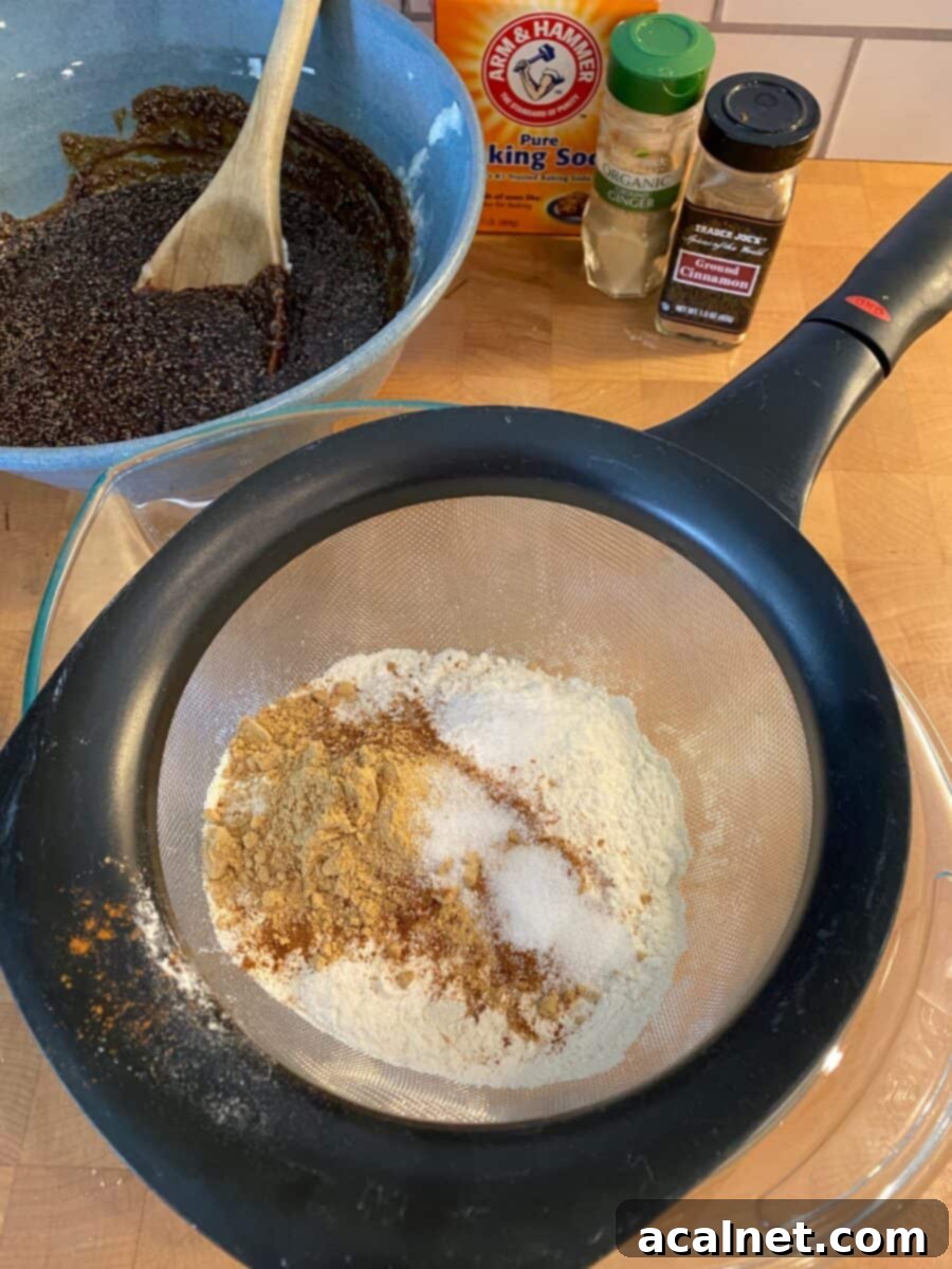 Dry ingredients being whisked together in a bowl, surrounded by various spice containers and another mixing bowl.