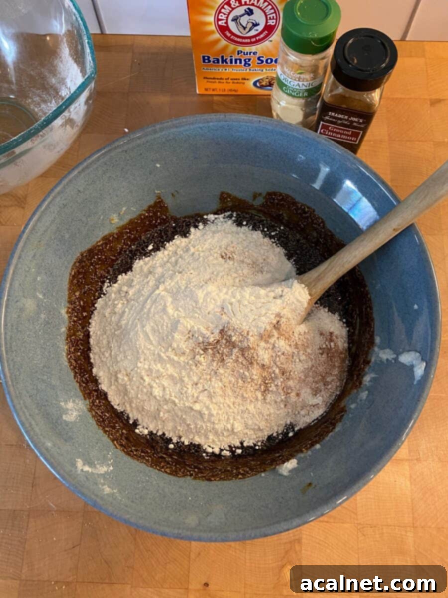 A mixing bowl filled with the dry ingredients, with spice containers neatly arranged to the side.
