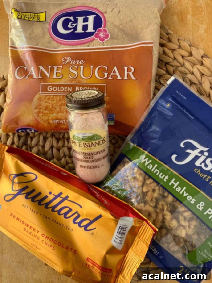 Ingredients for chocolate chip bars spread out on a cutting board, including flour, brown sugar, butter, eggs, chocolate chips, and walnuts.