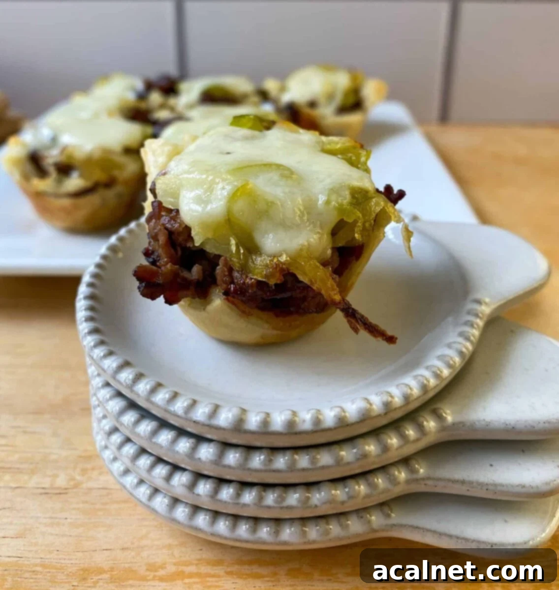 Philly Cheesesteak Poppers 11 mini cheesesteak bite on a stack of tasting plates.