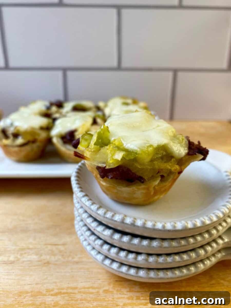 Philly Cheesesteak Poppers 5 Philly Cheesesteak Bite on a small stack of dishes with the serving plate in the background.