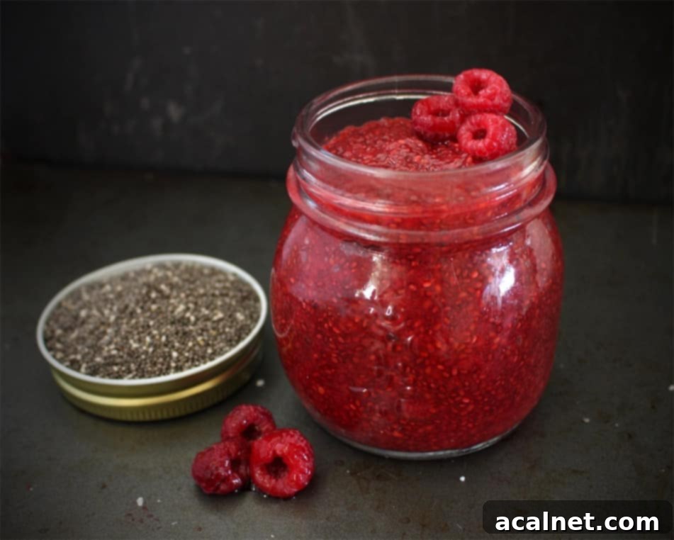 Jam in a glass jar on a black surface.