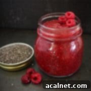 Jam in a glass jar on a black surface.